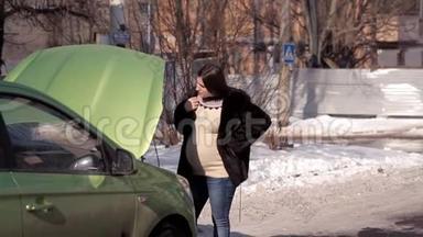 在冬天，一个怀孕的女孩正在寻找帮助，从路过的汽车修理一辆失败的汽车